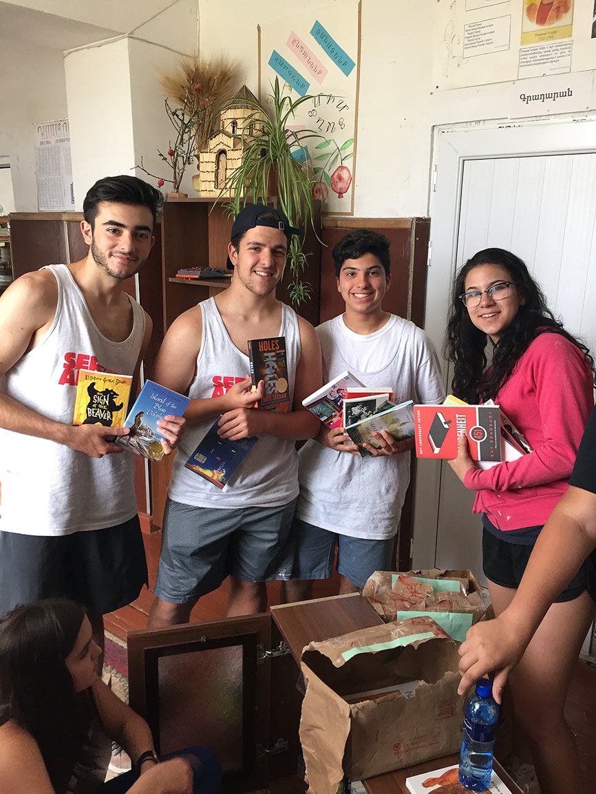 SERVICE Armenia 2016 participants delivering English language literature to the Lchashen village school. Pictured left to right: Lily Woodall, Alec Muradliyan, Mihran Markarian, Peter Chelebian (Book-in-a-Bag project sponsor) and Mara Tatevosian.